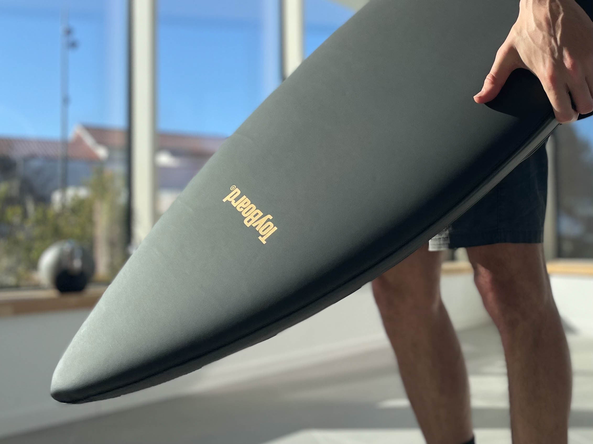 Man holding a Deluxe Black Gold ToyBoard upside down