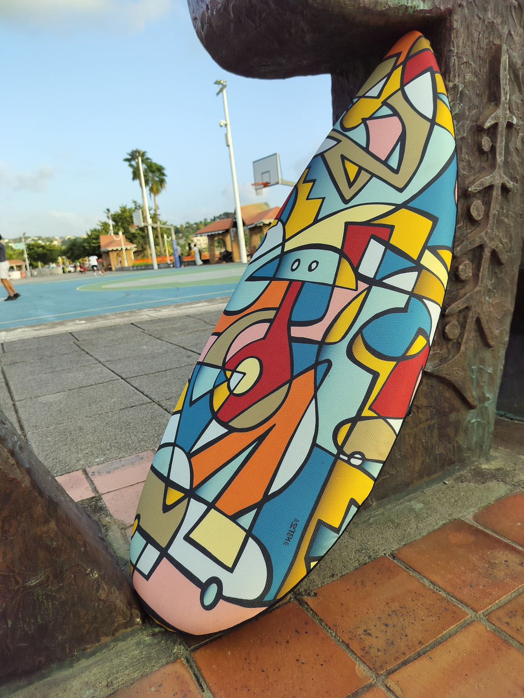 The Nils ToyBoard stading outdoors in front of a basketball court